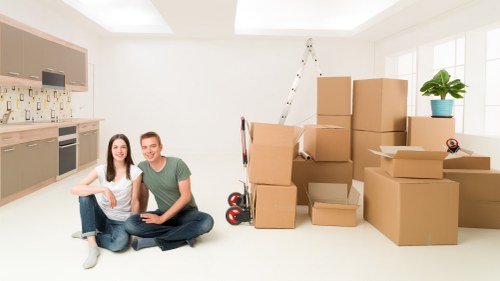 Local moving team organising packed boxes in a South London property