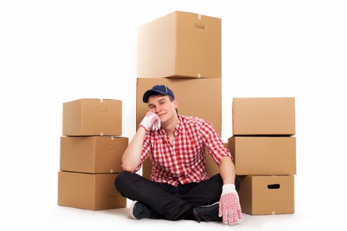Piano removal team protecting floors and moving a piano carefully in South West London